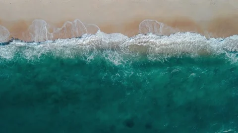 Expansive ocean waves cascading onto sandy coastal beach Tranquil beauty of Stock Footage 275082860