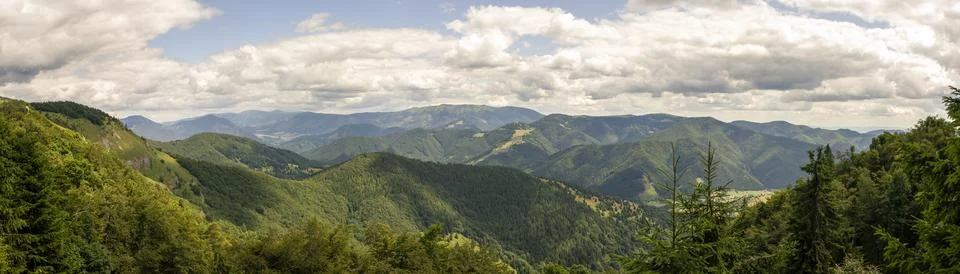 Expansive panoramic view of rolling green forested hills, mountain ridges a.. Stock Photos