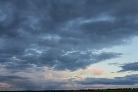 Expansive sky displaying dramatic cloud formations at sunset over a tranquil  Stock Photos
