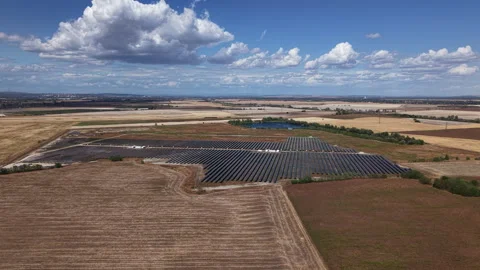 An expansive solar farm, generating clean energy, stretches across dry Stock Footage 345620274
