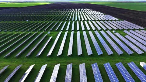 Expansive solar farm with rows of panels under clear blue sky Stock Footage 325087456