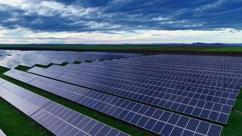 Expansive solar panel array capturing sunlight in a vast green landscape under a Stock-Footage 332099172