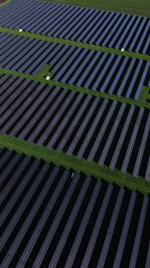 Expansive solar panel array reflecting the bright sunlight in a vast green field Stock-Footage 332041168