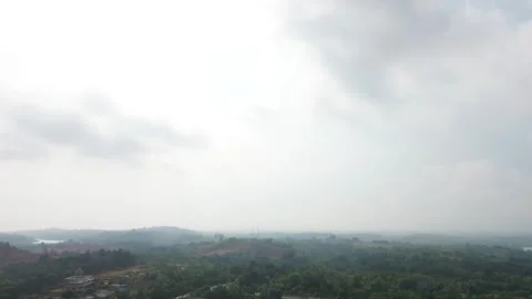 Expansive Verdant Landscape Under Overcast Sky with Distant Settlements 動画素材 319459580