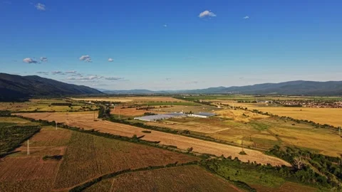 Expansive view of fields and mountains under clear blue sky in daytime Stock Footage 339167980