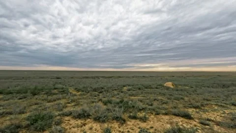 Expansive view of grassy plains under dramatic cloudy sky at dusk Stock Footage 340272962