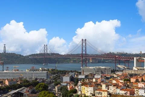 An expansive view of Lisbon, featuring the iconic red Ponte 25 de Abril suspe Stock Photos
