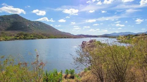 Expansive view of a tranquil lake, surrounded by distant hills and natural .. Stock Photos