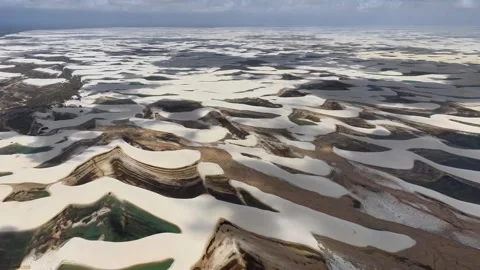 Expansive White Dunes and Dark Lagoon Patterns in Lençóis Maranhenses Video stock 342441031