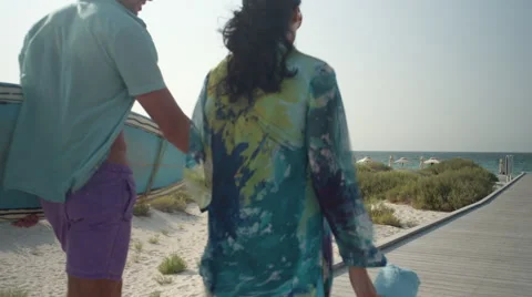 Expat couple carrying surfboard at beach. Stock Footage 64111353