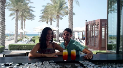 Expat couple with drinks at bar area. Stock Footage 64111390