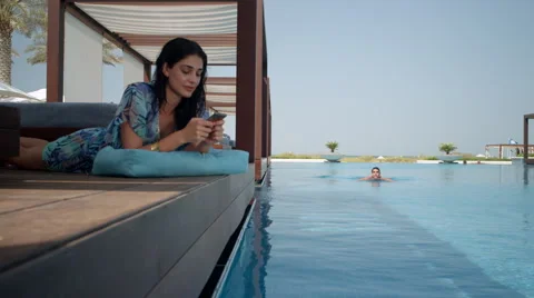 Expat couple taking selfie using mobile camera at poolside. Stock Footage 64114113