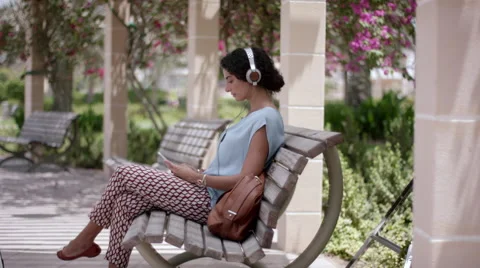 Expat woman using digital tablet and listening music on headphones. Stock Footage 63508875