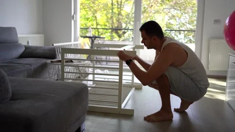 Expectant father preparing a nursery by assembling a wooden crib Stock Footage 329486353