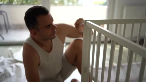 Expectant father preparing a nursery by assembling a wooden crib Stock Footage 329486385