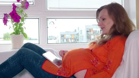 Expectant mother with tablet and credit card buying good in online shop website Stock Footage