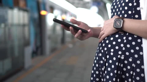 Expectant mother using phone while waiting on subway platform Stock Footage 272212379