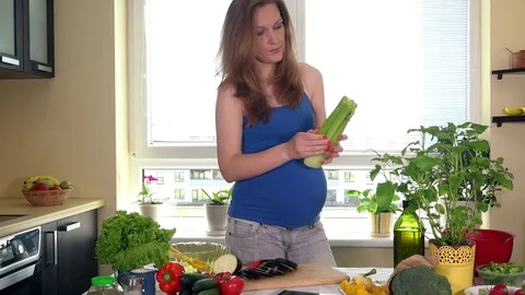 Expectant mother woman using a tablet computer to prepare vegetables salad Stock Footage 80764914