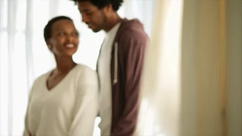 Expectant young father standing with his arms around his partner. Stockbeeldmateriaal 88405960