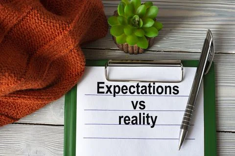 EXPECTATIONS VS REALITY - text in a notebook with a pen, cactus and a fragmen Stock Photos