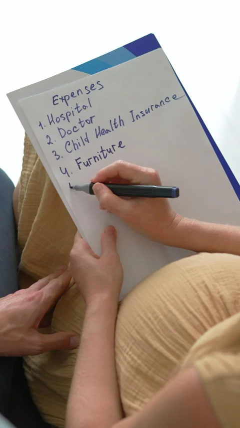 Expecting couple sitting on the couch discussing future baby expenses. Stock Footage 332659811