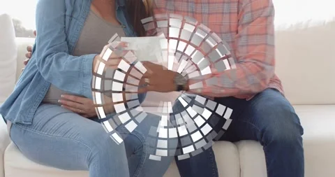 Expecting couple sitting sofa, woman bringing sonogram forward for prenatal Video stock 330004161