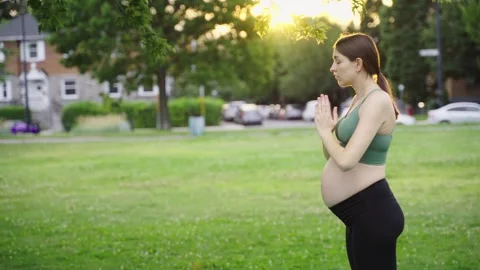 Expecting female in park doing yoga in her third trimester. Stock Footage 244411026