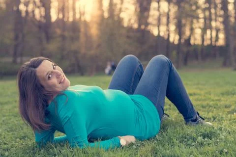 Expecting mother relaxing on grass. Stock Photos