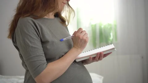 Expecting mother writing delivery checklist Stock Footage 309278564
