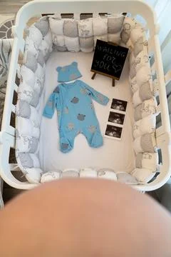 Expecting parent preparing a nursery for a new baby, with a cozy white crib deco Stock Photos