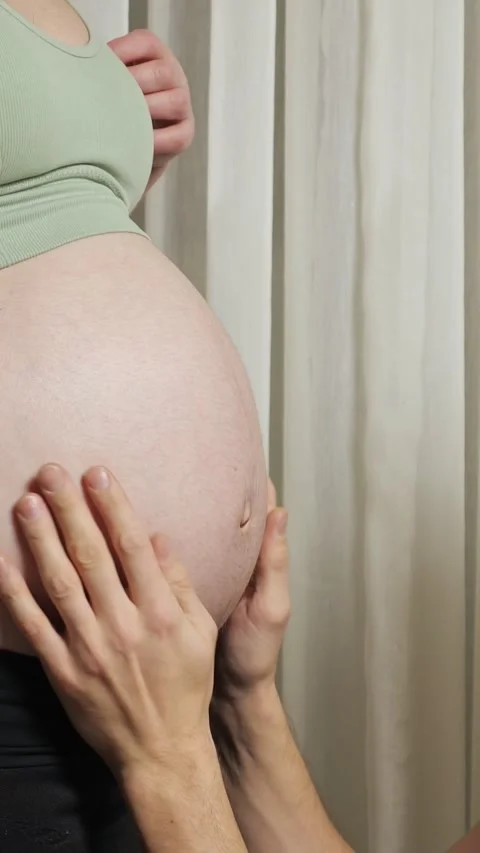 Expecting parents lovingly interacting with the pregnant belly as the caring Stockbeeldmateriaal 342908393