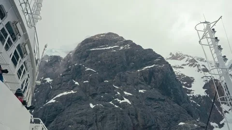 Expedition ship passes towering rocky mountain in Lemaire Channel Antarctica Video stock 339132017