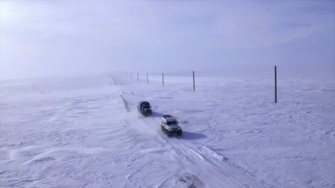 Expedition vehicles driving on a remote winter road Stock Footage 337037978