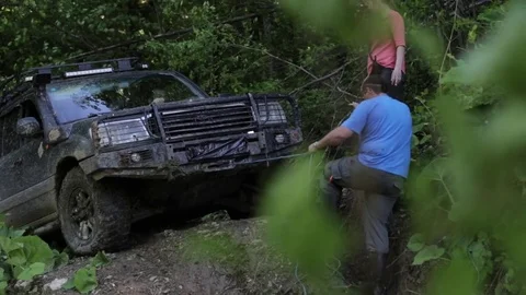 Expeditionary SUV trying overcom dangerous complex terrain at forest via winch. Stock Footage 76728190