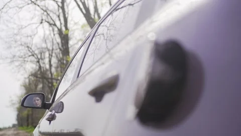 Expensive fuel for the car. Alternative energy. A woman opens a tank for Stock Footage 181929853
