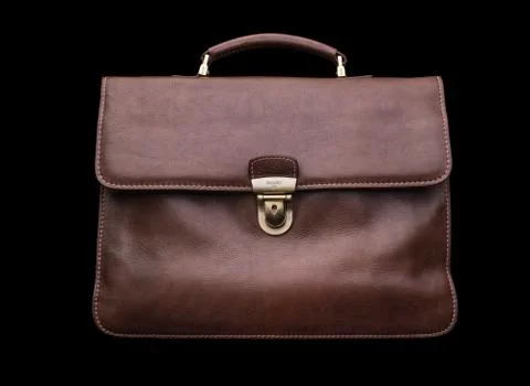 Expensive leather briefcase on a black background. Stock Photos