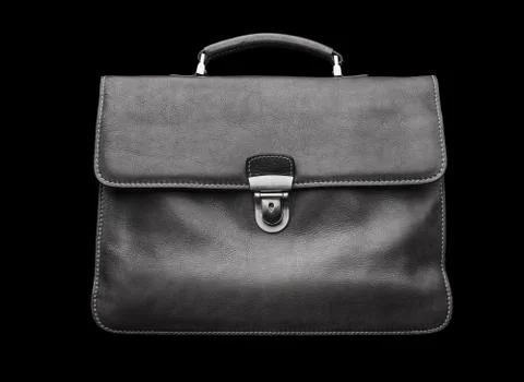 Expensive leather briefcase on a black background. Stock Photos