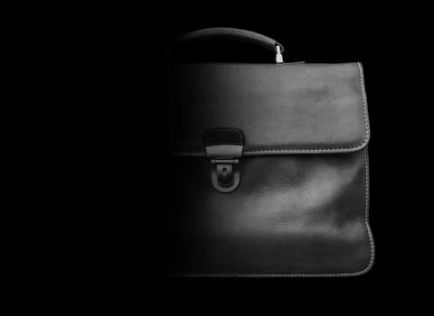 Expensive leather briefcase on a black background. Stock Photos
