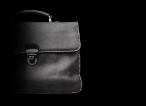 Expensive leather briefcase on a black background. Stock Photos