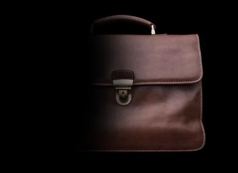 Expensive leather briefcase on a black background. Stock Photos