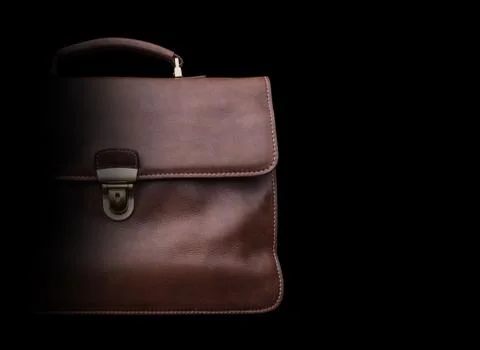 Expensive leather briefcase on a black background. Stock Photos