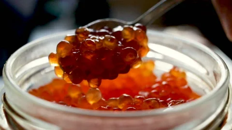 Expensive red caviar on a silver spoon. Close-up, real time, natural light, cont Stock Footage 107921569