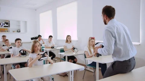 Experience augmented reality in a school. Teacher with pupils wearing VR glasses Stock Footage 111542891