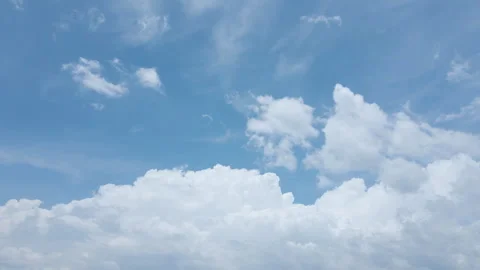 Experience the beauty of clouds smoothly moving in a bright blue sky Stock Footage 303465157