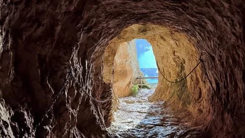 Experience the breathtaking cave view that splendidly overlooks the serene sea Stock Photos
