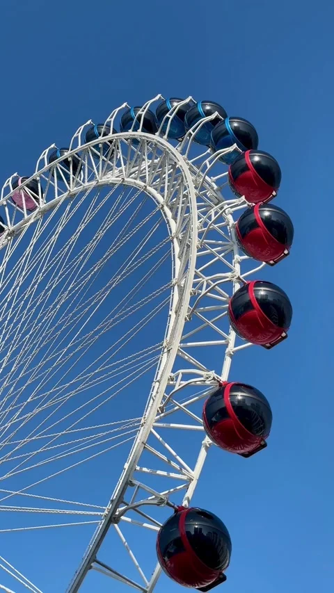 Experience breathtaking views from a colorful Ferris wheel on a sunny afternoon Видео 302264626