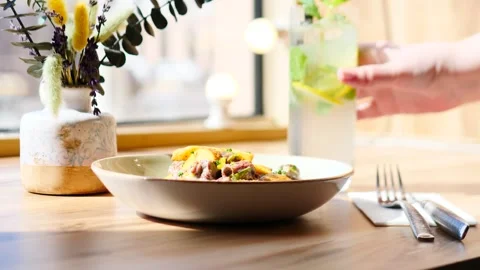 Experience a delicious meal paired with a refreshing drink and stunning floral Stock Footage 311872002