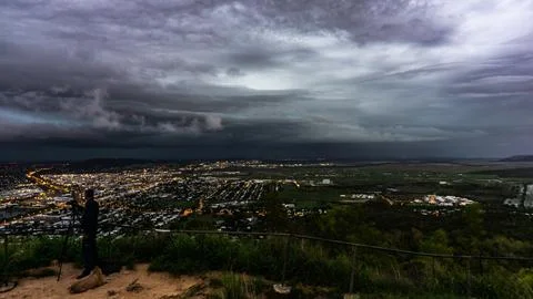 Experience the dramatic storm clouds unfolding over the city at dusk, showc.. Stock Photos