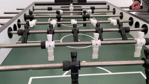 Experience the dynamic action of a foosball game, with players in constant Stock Footage 305843234
