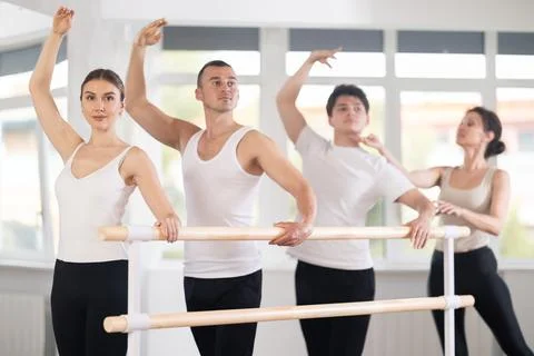 Experience female ballet instructor adjusting students form. Diligent girls and Stock Photos